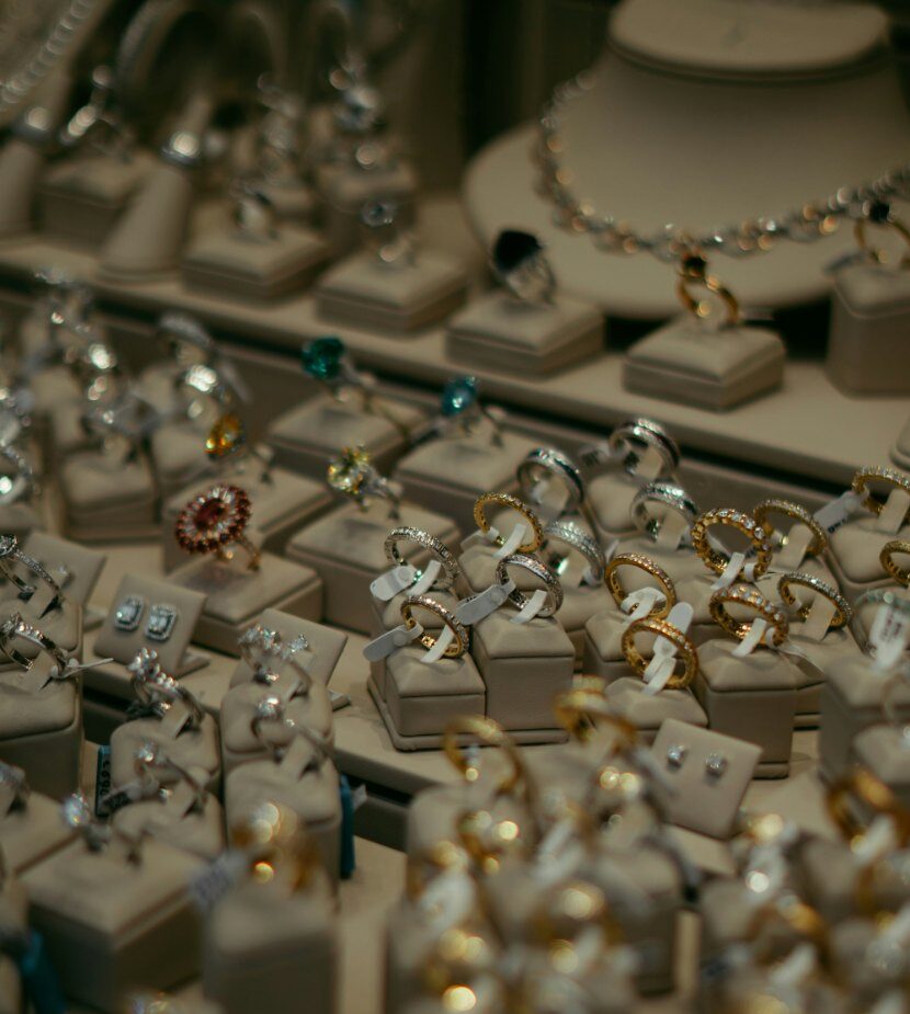 Jewelry store display of diamond engagement rings and wedding bands on white stands available for virtual jewelry consultation appointments